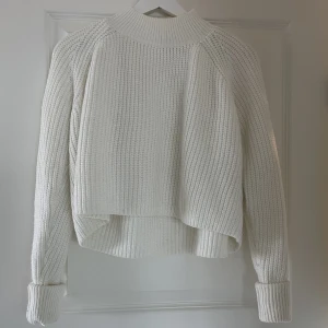 Stickad tröja - Stickad tröja från NA-KD med öppen rygg. Långa ärmar som man kan vika upp.