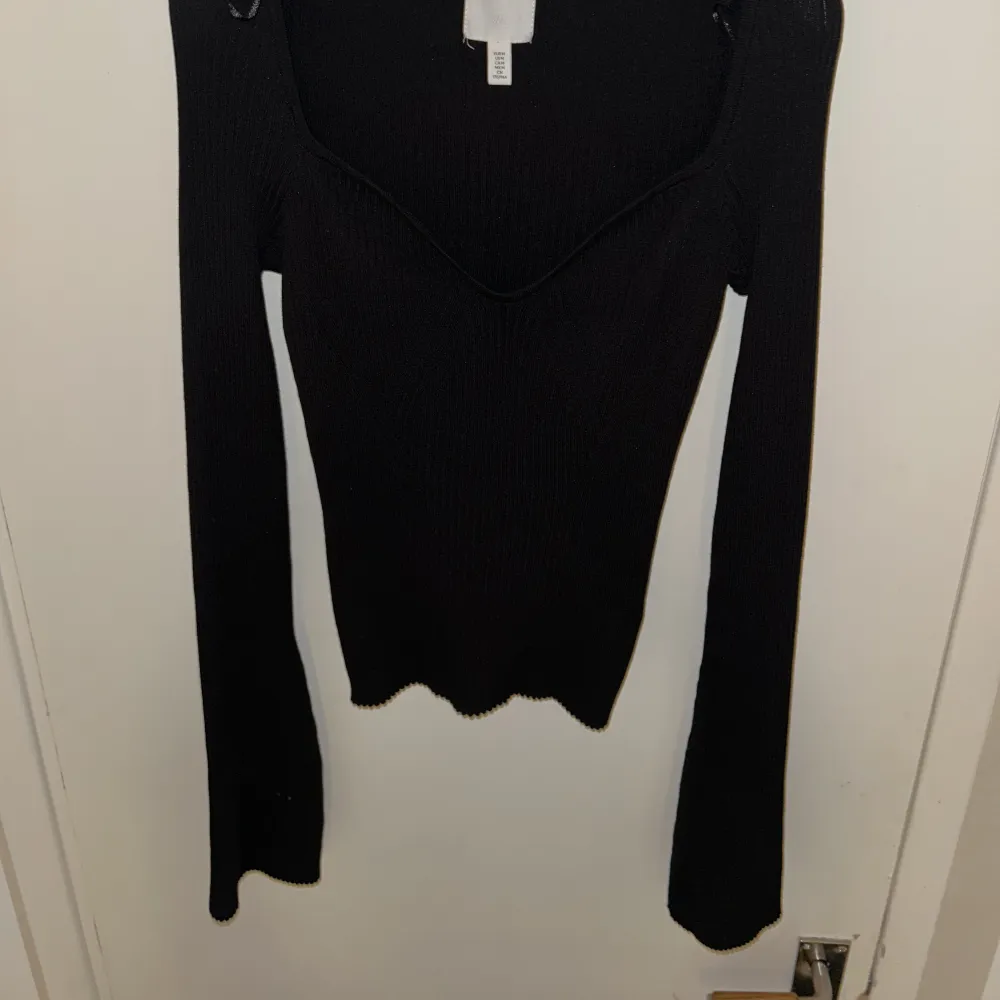 Ribbstickad svart tröja från h&m med lite volangärmar och urringning. Aldrig använd.. Toppar.