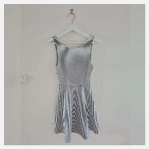 En kortare vit klänning med svarta små ränder. Har en dragkedja bak och ganska öppen rygg. Köpt från H&M, är i gott skick och storlek 34. 🤍