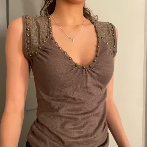 Super sött linne  - Super sött brunt linne med guldiga detaljer. Mycket bra skick. Köparen står för frakten. 