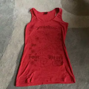 Jättefin röd tank top köpt på secondhand ❤️‍🔥jättefin print med rödskimrande bokstäver, sitter tajt på kroppen❣️ står att den kommer från Madonna 