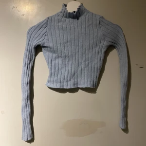 Blå stickad långärmad tröja - Långärmad stickad tröja. Väldigt tjock även fast den inte ser ut som det. Har lite turtleneck men inte fullt. Ribbad och stickad. Storleken är XS men tröjan är väldigt stretchig så passar S. Köpt från madlady. Passar så bra nu till vintern/hösten.