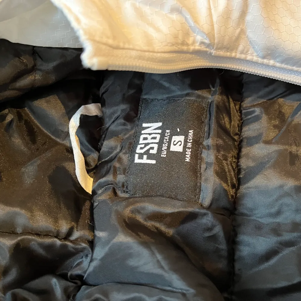 Storlek S Varm vinterjacka med luva och märket FSBN. Takit.