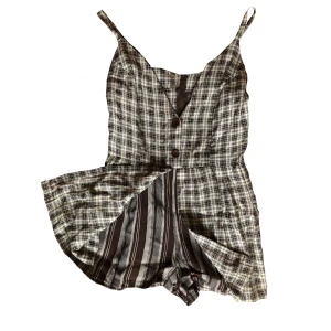 Unik vintage romper  - Vintage romper från Beyond Retro. Inbyggda shorts, dragkedja i ryggen, stora knappar fram.