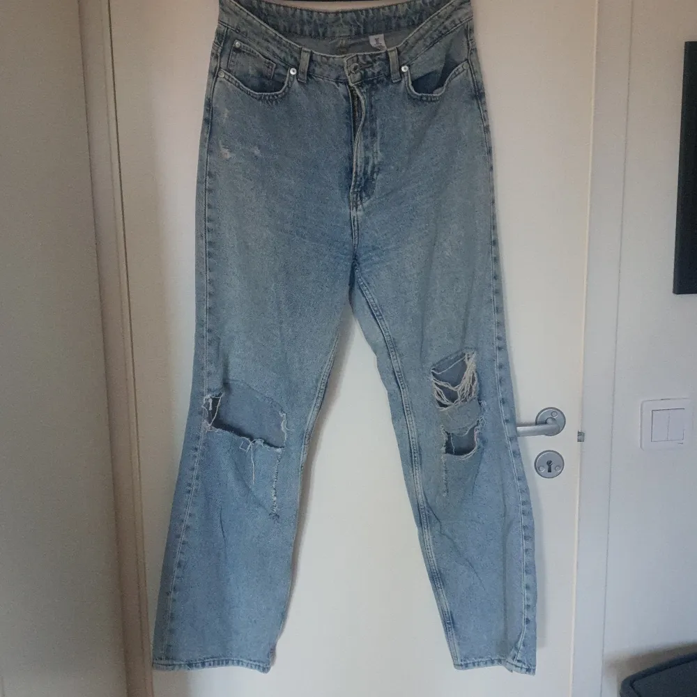 Ett par denim jeans från hm med hål på knäna. . Jeans & Byxor.