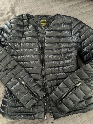 Tunnare jacka  - En fin tunnare jacka från Ralp lauren, som är i nyskick. Ser svart ut på bilden men är svart/mörk blå 