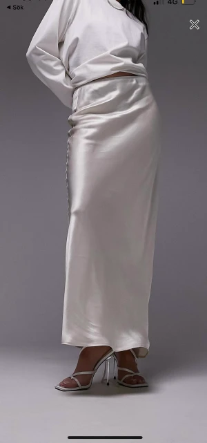 Naturvit maxi kjol av satin  - Säljer min helt oanvända naturvita maxi kjol i storlek Eu 34 från Asos. Prislappen är kvar. Säljer den på grund av att jag upptäckte att den liknade en jag har. Orginal priset på kjolen är 539kr men priset går att diskuteras. 