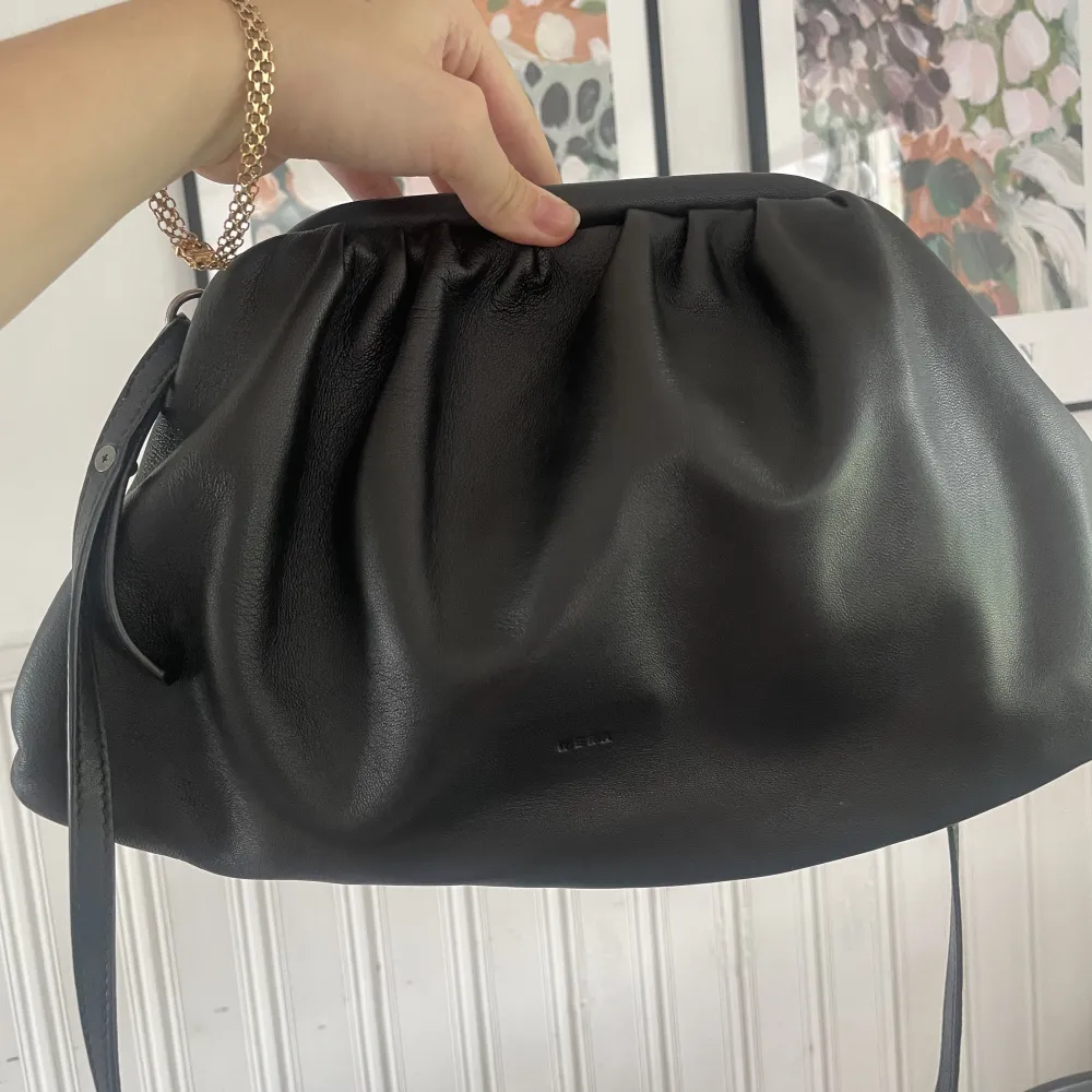 En svart axelremsväska från märket Wera, köpt på Åhléns för 1000 kr, och knappt använd efter det. Den är väldigt rymlig för att vara en liten väska.. Väskor.