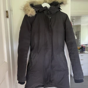 CANADA GOOSE VICTORIA PARKA - Säljer min Canada Goose då den tyvärr inte kommer till användning, jätteskön tjock jacka som man aldrig fryser i!  Storlek S, sann till storlek. Tyvärr en liten reva vid fickan, men inget stör funktionen. Den är svartare än vad som upplevs på bilderna 🕺🏼