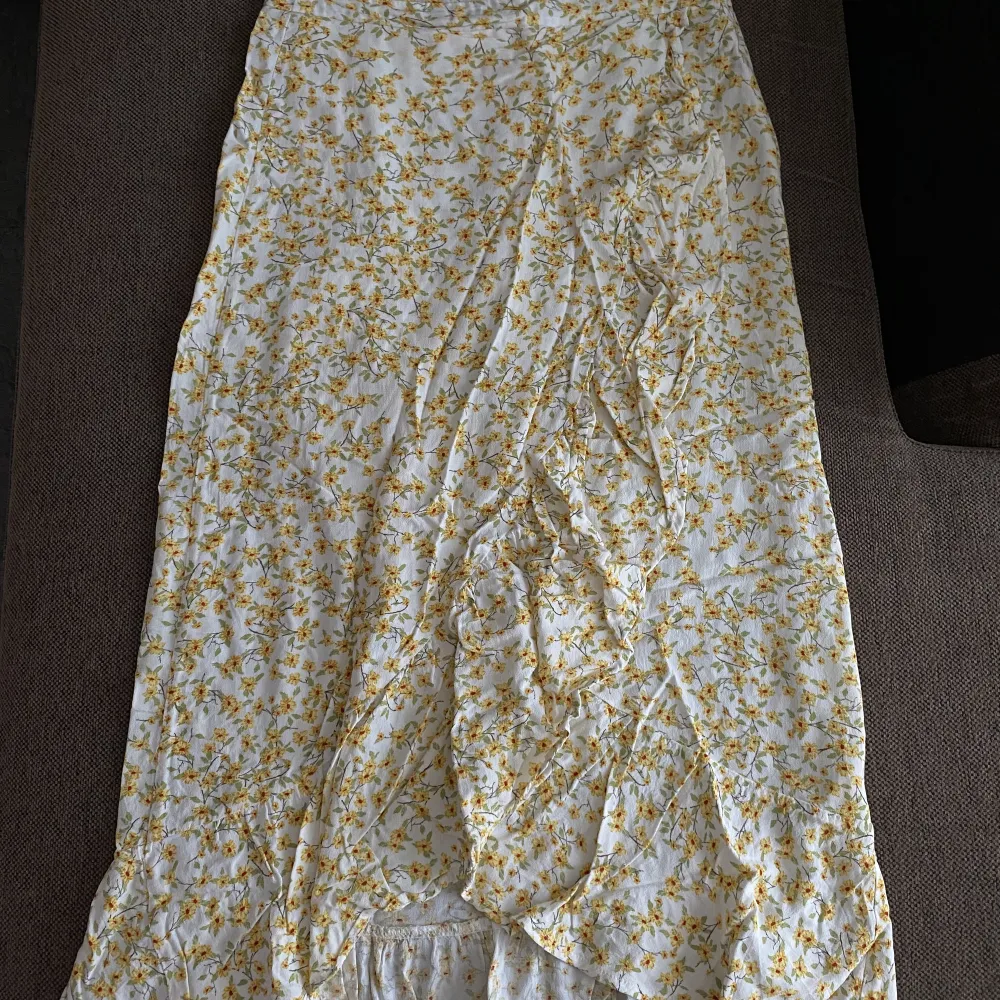 En vit kjol med gula blommor från Pull&Bear. Storlek S . Kjolar.
