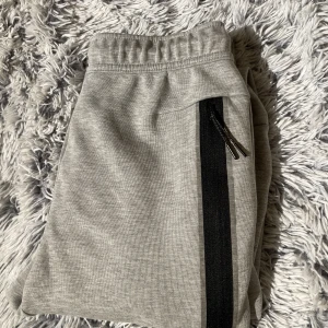 Nike tech byxor  - gråa nike tech byxor i strl xs, lite noppriga men annars bra skick, pris kan diskuteras vid snabb affär. har även tröjan till, 700 för båda delarna! 🤍först till kvarn !!