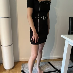 Svart bältesklänning från Boohoo - Festklänning med dragkedja och justerbart bälte. Den är i storlek xs men skulle nog sitta bättre på någon som har storlek xxs då den är lite tajt i axlarna. Har använts två gånger och ser helt ny ut. Kan mötas upp i Göteborg t.o.m fredag, sen Helsingborg
