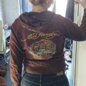 Ed hardy hoodie  - Grymt cool Ed Hardy zip up hoodie🌟 Några stenar saknas. Säljer då jag tycker den är lite för kort i ärmarna. Så det är att tänka på om man har väldigt långa armar😊 Strl XXL men skulle säga passar xs-m.