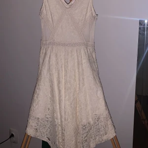 Kläning - En söt spets klänning. V skuren nedtill vilket gör den kortare på sidorna. Använd vid få tillfellen