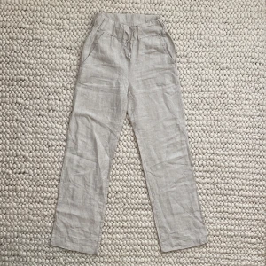 Linne byxor från A-dsgn - Säljer dessa beiga linnebyxor från A-dsgn. De är väldigt långa därav har de fått lite slitage nertill. Storlek XS, jag är 164cm och dom är nog 5 cm för långs för mig.