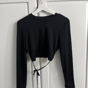Långärmad med öppen rygg  - Fin svart långärmad med öppen rygg, säljs för att den ej kommer till använding