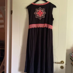  Omlottklänning - Aldrig använd omlottklänning från Odd Molly i stl:3 Svart med korall-rosa brodyr. 