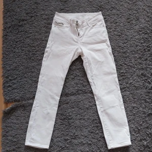 Vita jeans från Lindex  - Vita jeans från lindex. Storlek 38. Dragkedja på bakfickorna.  Knappt använda i mycket fint skick.  Betalning via swish och köparen står för frakten. 