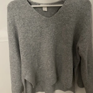 Stickad tröja  - Super skön grå stickad tröja, lite liten för mig därför säljer jag. Har slits på sidorna och är lite längre i ryggen. 