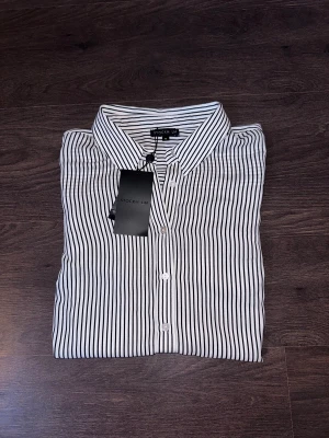 Randig skjorta - Helt ny och oanvänd skjorta från STOCK LM med prislapp kvar på.   Rensar ur min garderob från en hel del oanvända kläder🌼 Kika och se om du ser något mer i min profil som du gillar så skickar jag med det till dig också!😊 Fler kläder kommer! 