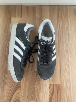 Gråa Adidas Gazelle. Bra skick men dem har lite slitage på den vänstra skon i fram som man kan se på bild 2. Sulan i har även blivit lite missfärgad. Skriv för tydligare bilder på defekterna. Storlek 40 2/3 och passar bra på mig som har storlek 40 annars💕