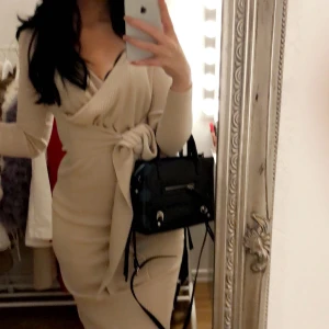 Ribbad midi-klänning - Ribbad midi-klänning från Bubbleroom i storlek S. Man kan stylea klänningen på olika sätt med hjälp av bandet som ni ser på de två första bilderna. I mycket bra skick då den endast är använd 2 gånger. Nypris: 699kr