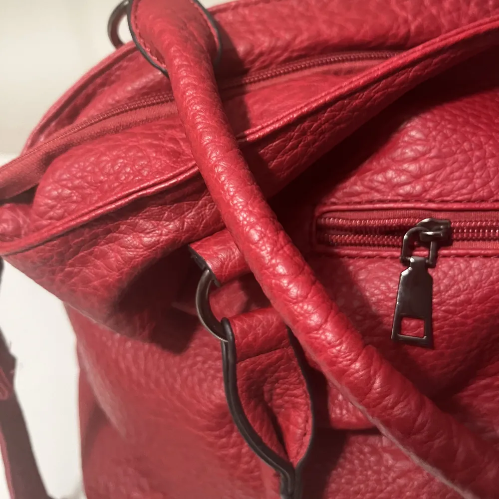 Fin röd shoulder väska i nästintill nyskick i slittålig läderimitation. Silver och svarta detaljer, flera fack och dragkedja inuti och utanpå och en avtagbar axelrem❤️ Köpt för 800 kr. Accessoarer.