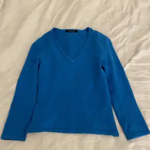Väldigt fin blå stickad tröja som inte kommer till användning!