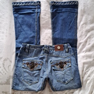 ANTIK DENIM jeans - Säljer dessa supercoola ANTIK DENIM jeansen (storlek 28) i jättefint skick🦅🤎 Jeansen är lågmidjade i bootcut-modell med superfina detaljer och häftigt broderi på bakfickorna💙 Hör av dig vid funderingar och använd gärna "köp nu"🫶 Måtten i kommentarerna!☆☆☆