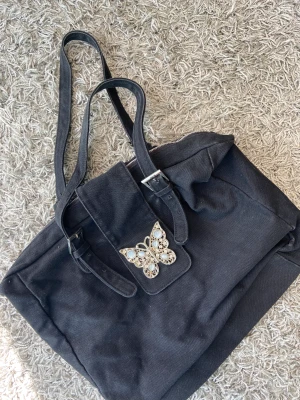 Väska - Snygg stilren väska med en fjärlisdetalj :)
