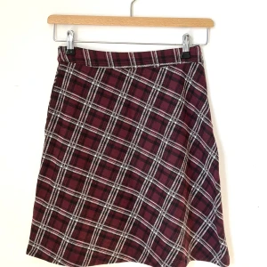 Rutig kjol i rött och svart - Snygg kjol i vinrött från Tom Tailer. Storlek 36. Brittisk skoluniformkänsla. Fint skick!