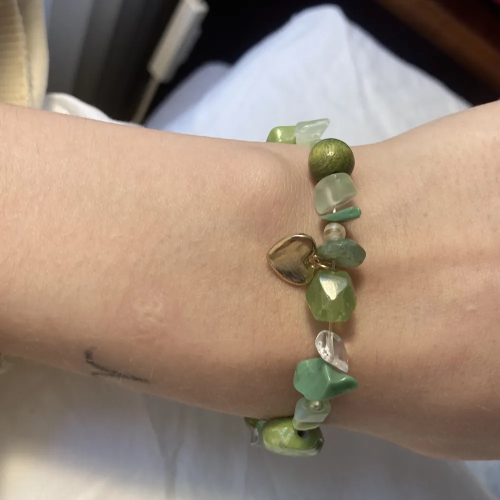 Egengjort armband med pärlor i olika gröna nyanser, 2 guldberlocker samt äkta kristaller i både grönt och genomskinligt. Har ännu fler smycket så kolla min profil!💕. Accessoarer.