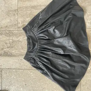 En svart läderkjol som aldrig är använd med prislappen kvar, designad i Paris 
