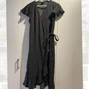 Ny sommarklänning (L) - En jättefin sommarklänning från veromoda på marinblå botten med vita prickar. Då den är av omlottmodell så är den lätt att anpassa efter kroppen och ger fina former. Säljes pga dubblett. Finns i centrala Uppsala  