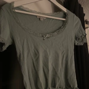 Söt topp från Pull & Bear - Säljer denna gulliga turkosa topp med lite spets detalj på sidan av armarna + rosett där fram pga den inte kommer till användning!  Liten defekt på ena armen med spets (litet hål, men man tänker en påt)