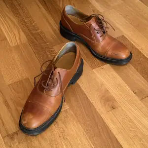 Fina låga Dr.Martens i äkta läder 👞👞 Lite slitna i fram, men har använts väldigt sparsamt. Inköpta för ett antal år sedan. Storlek 39. 