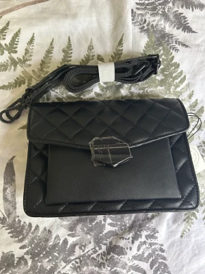 Don Donna axelremsväska - Helt ny svart axelremsväska från Don Donna. Justerbar och avtagbar axelrem.   Mått: höjd 15 cm, bredd 20 cm, djup 8 cm.  Helt ny med lappar kvar