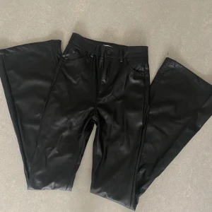 Skinnimmitation byxor - Skitsnygga fake läder utsvängda mellan midnatt byxor från Pull&bear. Stretchiga och super sköna! Aldrig använda. 