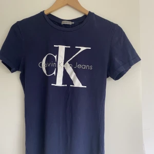 Calvin klein T-shirt  - Marinblå Calvin klein T-shirt med figursydd passform. Använd ett fåtal gånger så produkten är inprincip i nyskick.  Nypris 499:-   Frakt ingår ej 