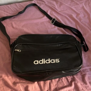 Adidas väska - Säljer denna as coola adidas väska för jag har tröttnat på den, det finns inga defekter förutom att dragkedjan har gått sönder och väskan inte går atg stänga. Men det är inget jag stört mig på💕