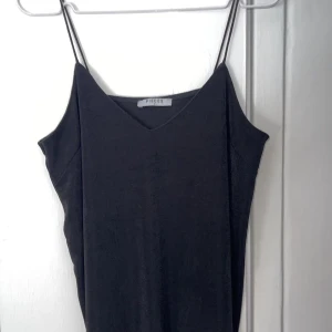 Svart linne  - Svart flowigt linne med tunna band. Superfint till sommaren. Vet inte exakt vart den är ifrån men tror Vila. 