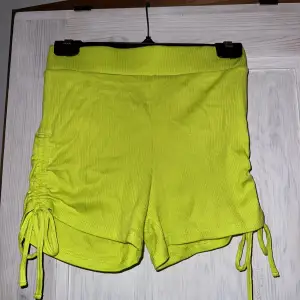 Shorts i neongrön/stark ljus grön. Har knytningar på sidan så kan göras kortare och längre. Aldrig använda prislapp kvar.