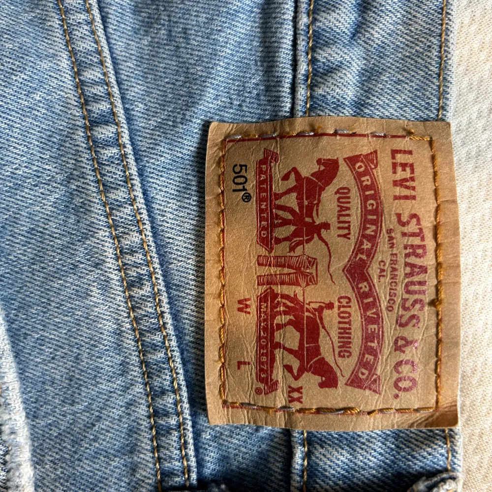 Levi’s 501 in size 25 and 32 inseam! Minor discoloration shown in second photo. These have a store string going through the waist band as they used to be too small for me. The Levi’s logo was resewn vertically which is shown on the last photo. 99% cotton!. Jeans & Byxor.