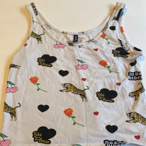 Tröja  - Ett vit linne med massa olika tryck på. 