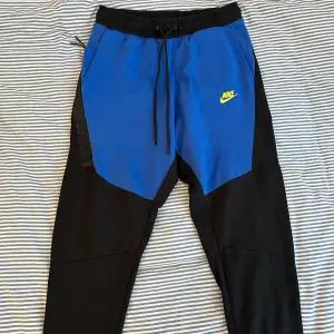 Nike tech fleece byxor i blå och svart färg. Endast prövade ett par gånger!
