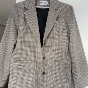 Kavaj - Snygg mönstrad kavaj från NAKD. Använd en gång, ser ny ut. Är i storlek 36 men är oversized!