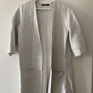 Kofta - En lite längre finstickad kofta i bomull. Trekvartsärm. Fint skick, knappt använd. 