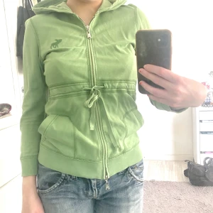 Huvtröja/Kofta - Jättefin grön  huvtröja/kofta som är tunn och bra till våren/sommaren. Den har en knytning i mitten som kan vara öppen ifall man vill. Köpt secondhand och knappt använd. 