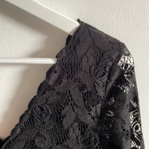 Klänning i spets - Klänning i spets med innerfoder.  V-ringad fram och bak. Okänt märke