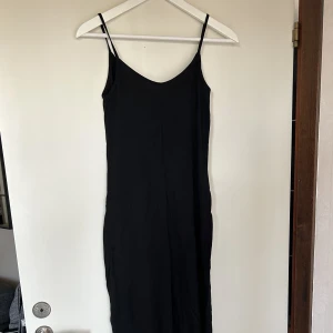 Svart långklänning med slits  - Svart lång klänning med hög slits på båda sidorna. Storlek XS men är som en S, då den är lite stor i storleken. Klänningen är stretchig. 